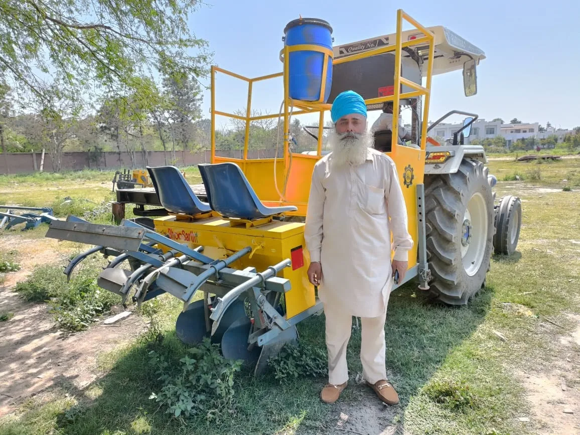 Farmer standing with a BhooSarthi two-row sugarcane planter